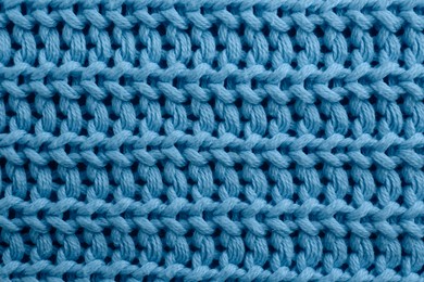 Beautiful light blue knitted fabric as background, top view