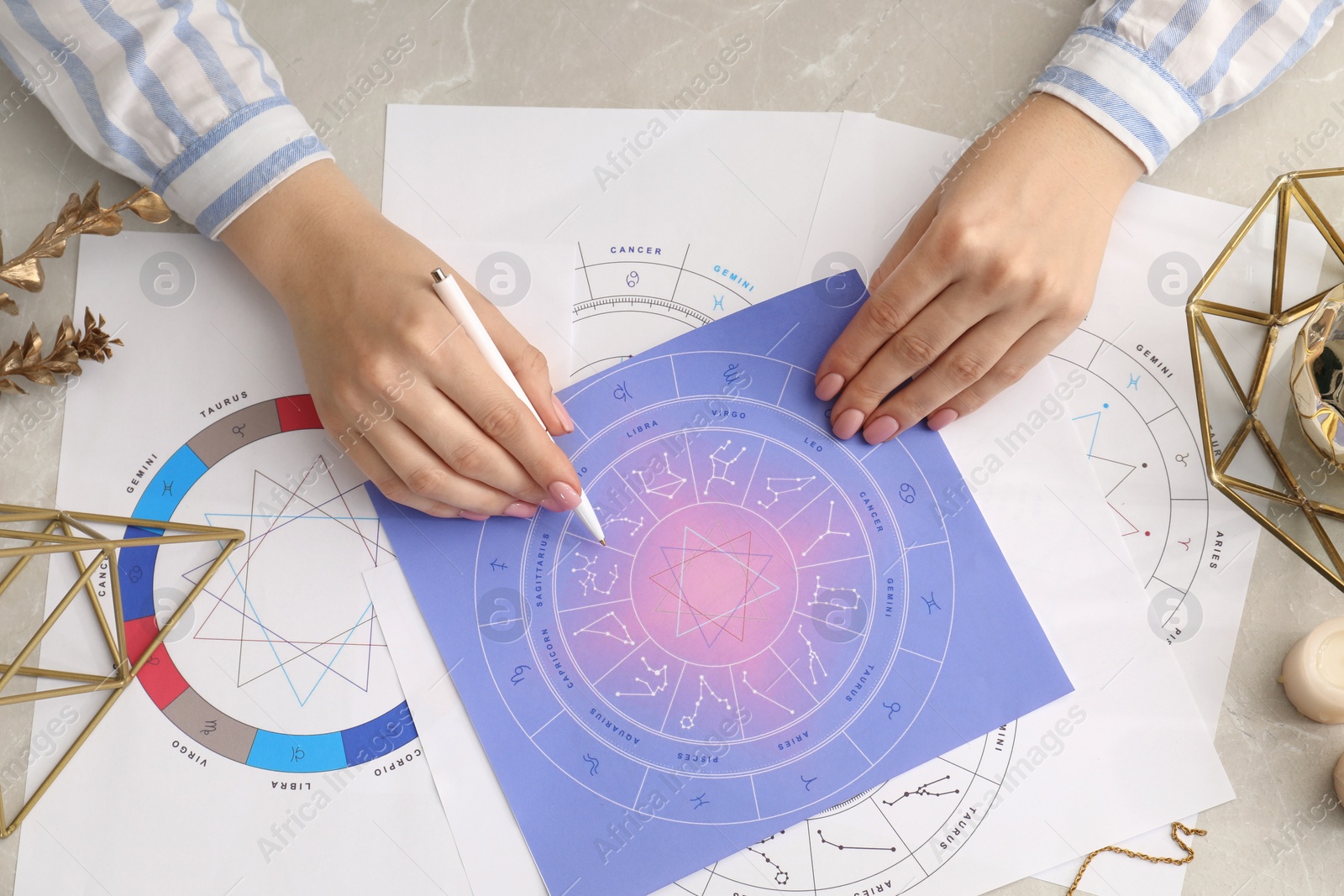 Photo of Astrologer using zodiac wheel for fate forecast at table, top view. Fortune telling