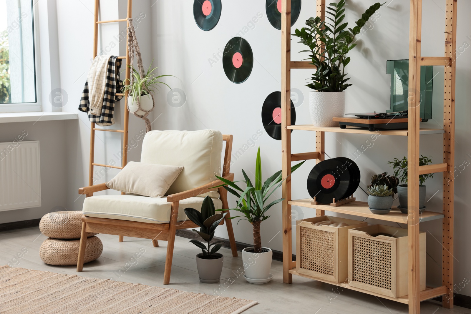 Photo of Living room interior with stylish turntable on wooden shelving unit and vinyl records