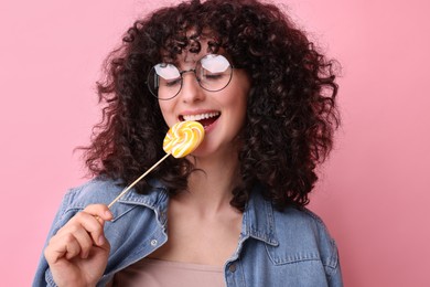 Photo of Beautiful woman with lollipop on pink background