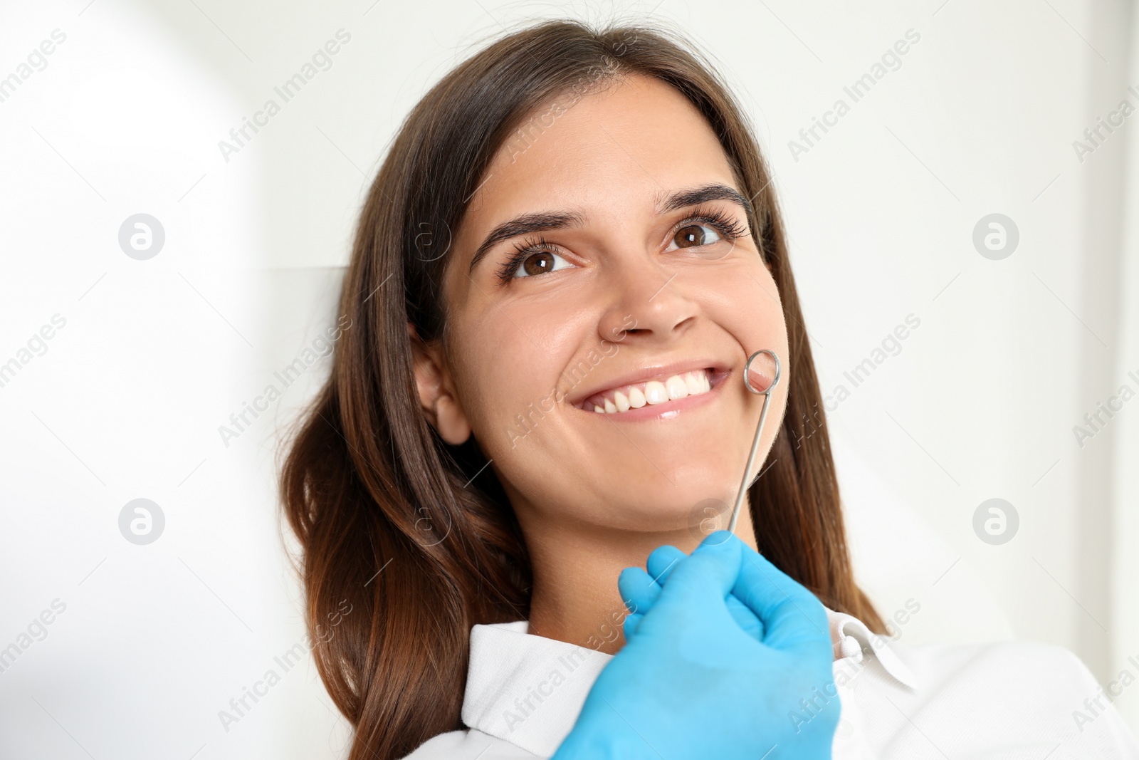 Photo of Dentist examining patient's teeth in modern clinic. Cosmetic dentistry