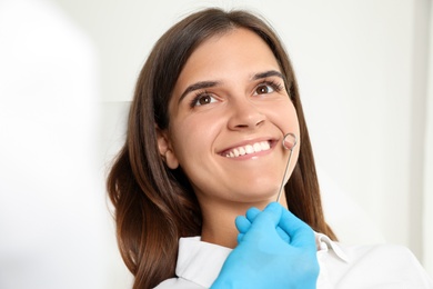 Dentist examining patient's teeth in modern clinic. Cosmetic dentistry