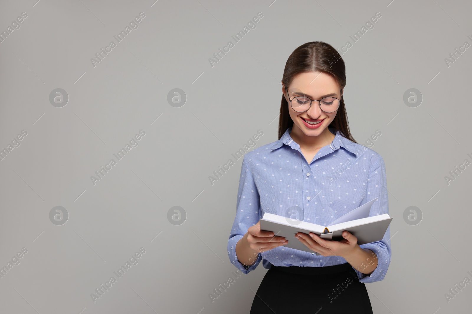 Photo of Portrait of beautiful young teacher on grey background. Space for text