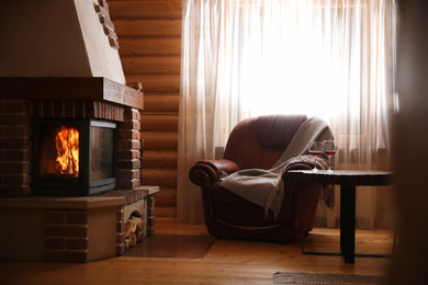 Photo of Modern cottage interior with stylish furniture and fireplace. Winter vacation