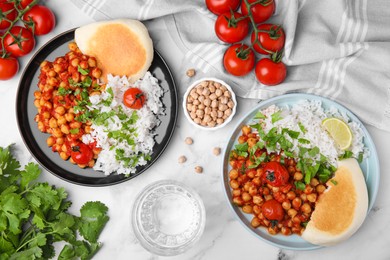 Photo of Delicious chickpea curry with rice served on white marble table, flat lay