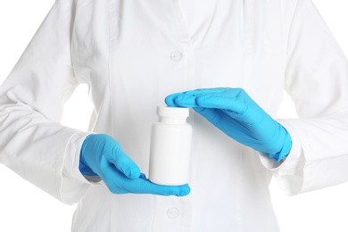 Photo of Doctor in medical gloves holding bottle of pills on white background