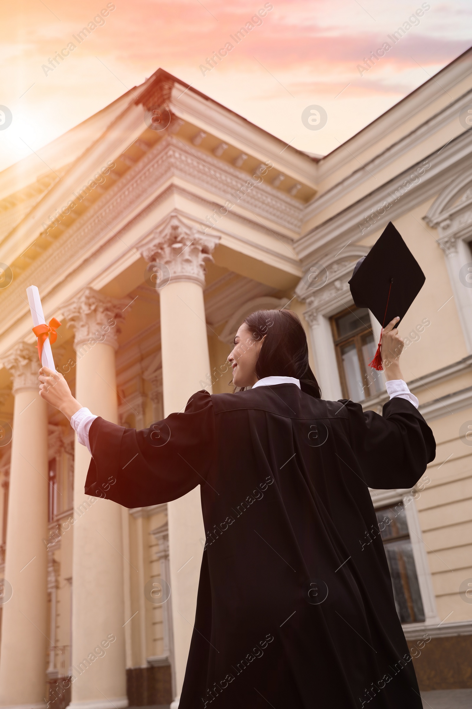 Photo of Student with diploma after graduation ceremony outdoors, low angle view