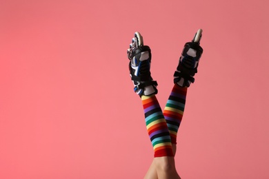 Photo of Woman with roller skates on color background, closeup. Space for text