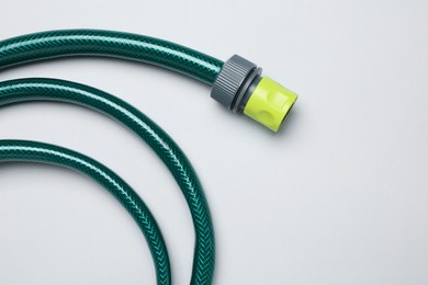 Photo of Watering hose on light grey background, top view. Space for text