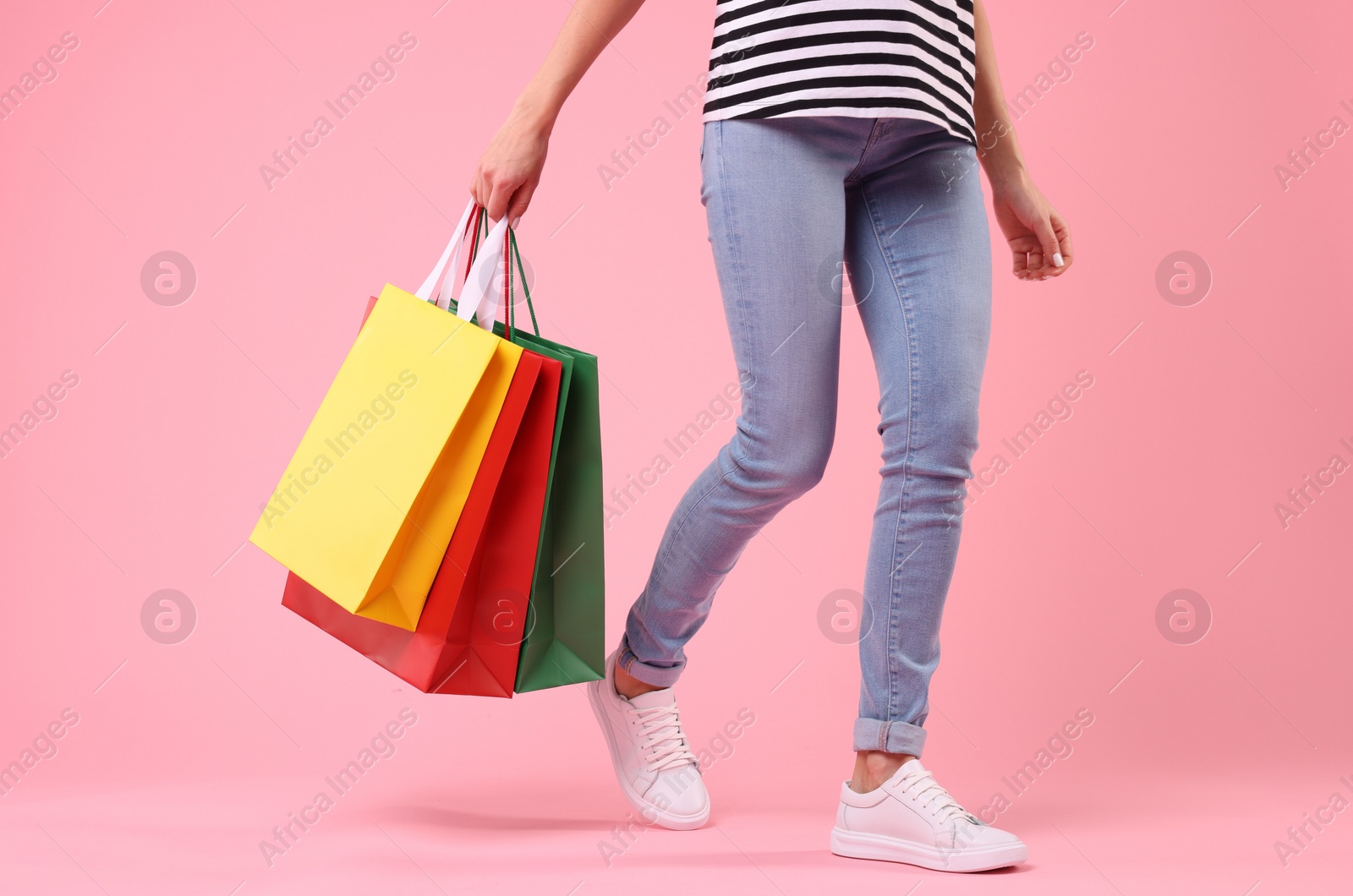 Photo of Woman with shopping bags on pink background, closeup