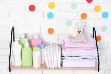 Photo of Baby accessories on shelf near white brick wall