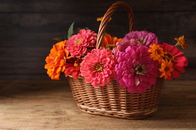 Beautiful wild flowers in wicker basket on wooden table