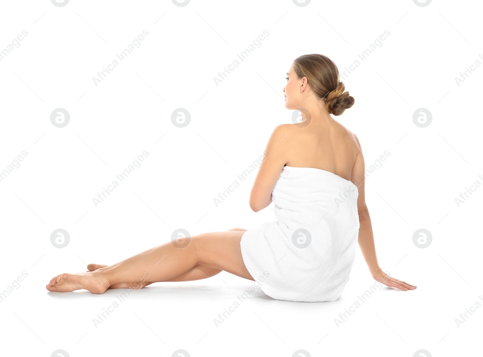 Photo of Young woman with soft towel sitting on white background