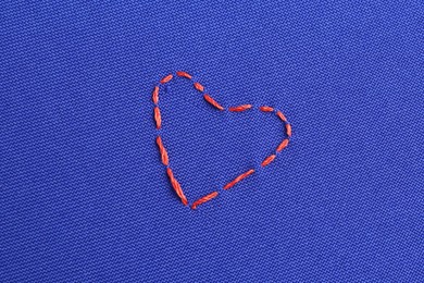 Photo of Embroidered heart on blue cloth, top view