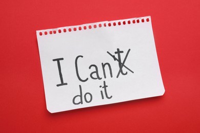 Photo of Motivation concept. Changing phrase from I Can't Do It into I Can Do It by crossing out letter T on red background, top view