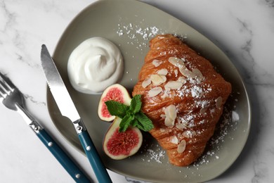 Photo of Delicious croissant with fig served on white marble table, top view