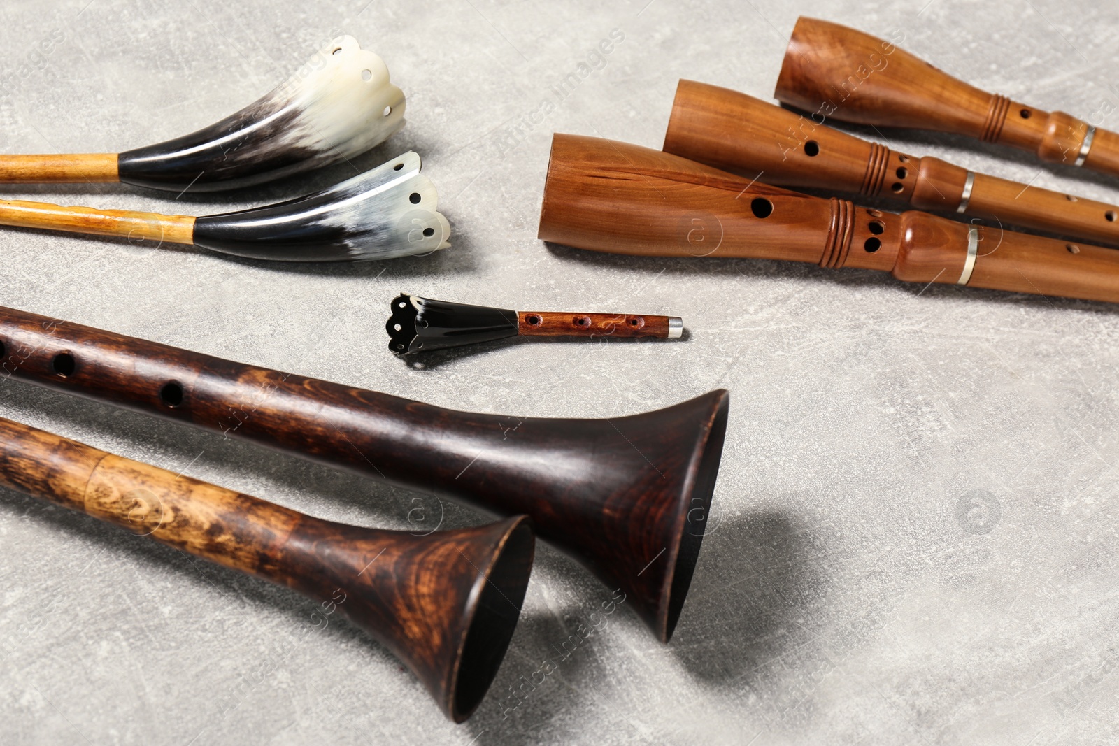 Photo of Vintage zhaleikas and bryolkas on light grey background. Woodwind musical instruments