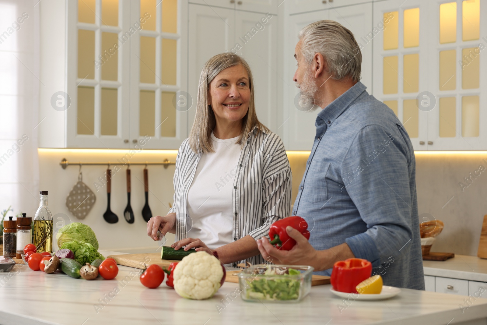 Photo of Happy senior couple cooking together in kitchen