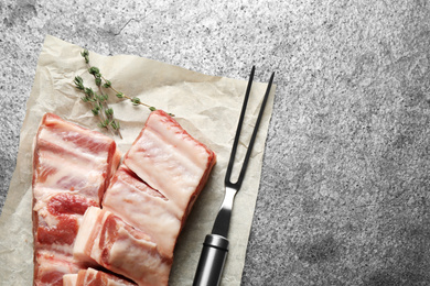 Photo of Raw ribs with thyme on grey table, flat lay