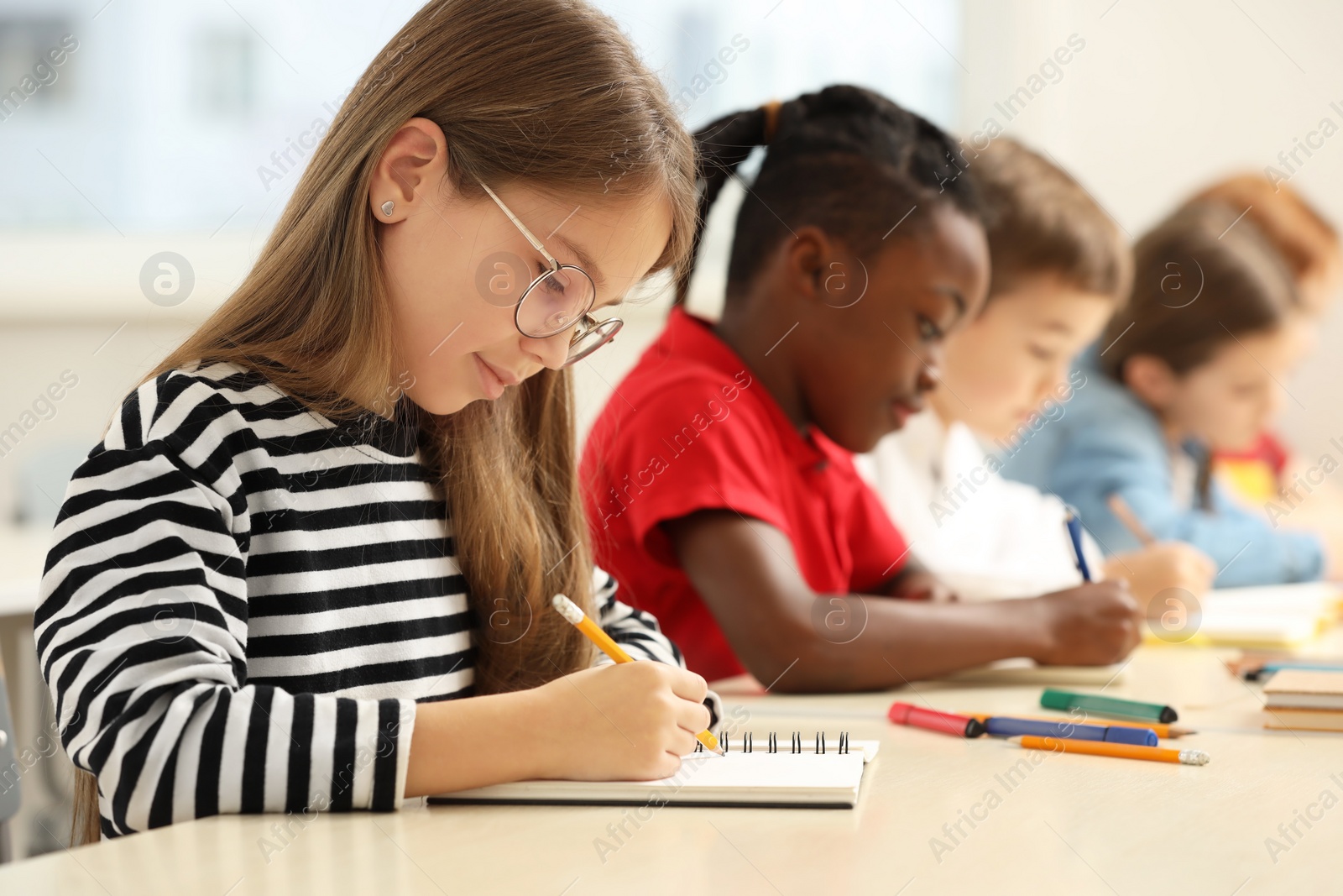 Photo of Cute children studying in classroom at school