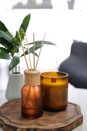 Photo of Reed air freshener and candle on table indoors