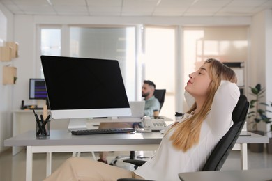 Young businesswoman relaxing in office chair at workplace