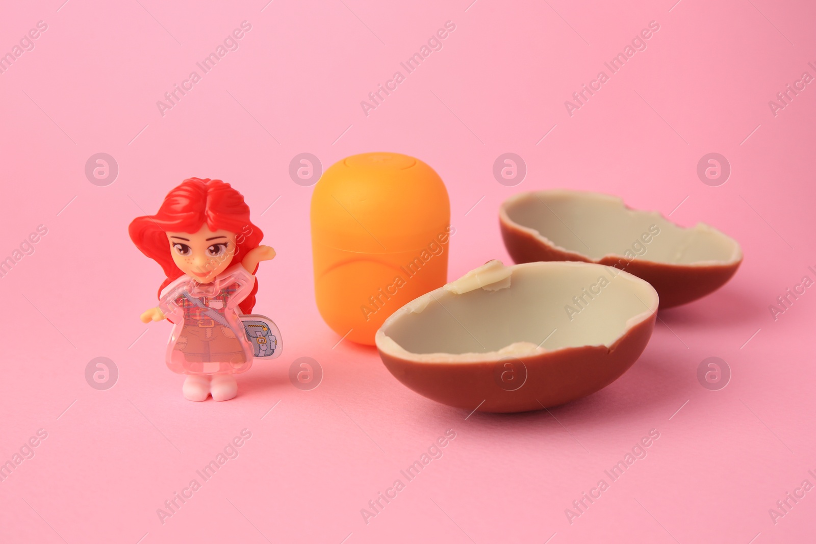 Photo of Slynchev Bryag, Bulgaria - May 25, 2023: Halves of Kinder Surprise Egg, plastic capsule and toy on pink background