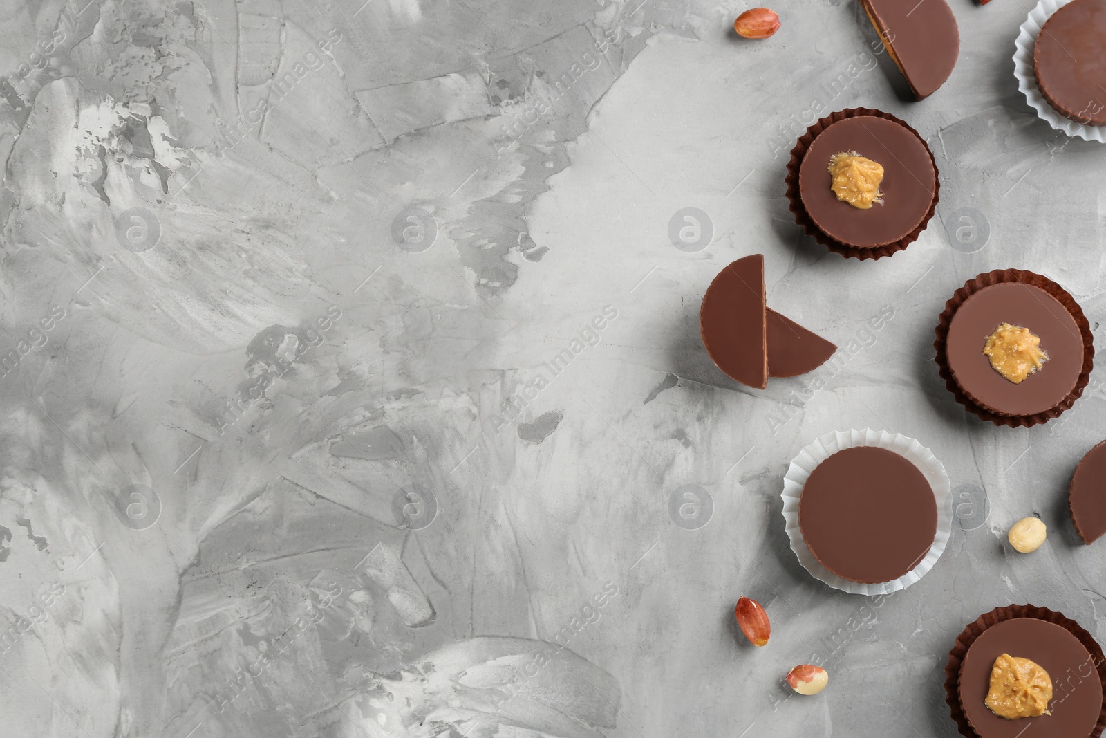 Photo of Delicious peanut butter cups on light grey table, flat lay. Space for text