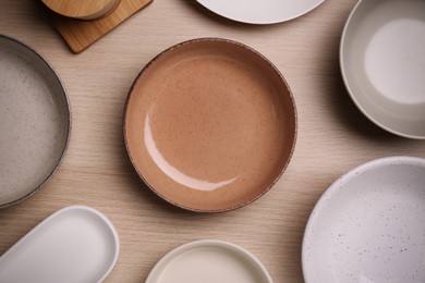 Photo of Different plates on wooden table, flat lay