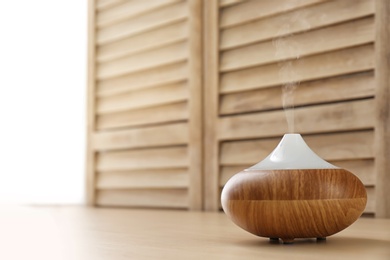 Photo of Modern aroma lamp and space for text on blurred background