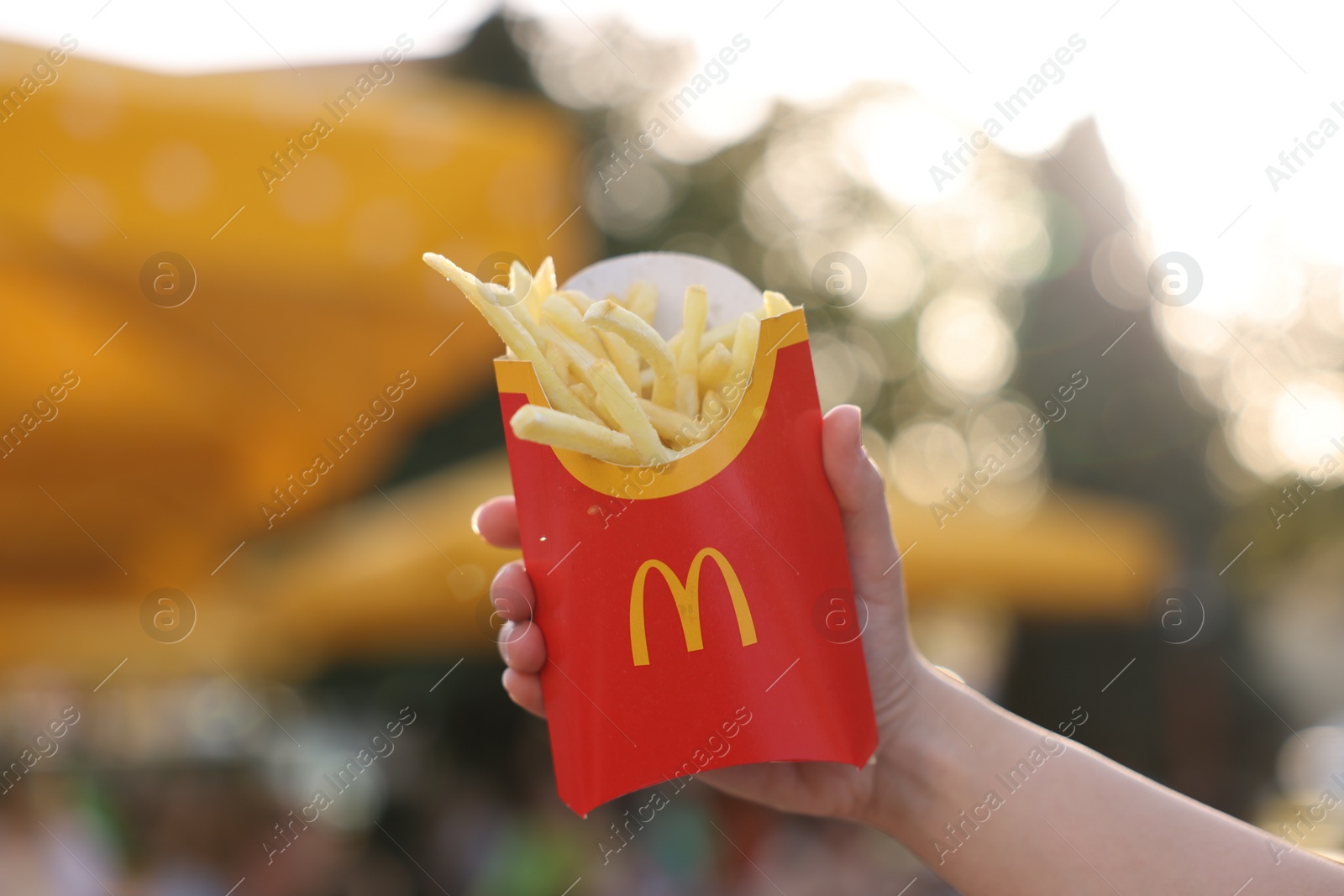 Photo of Lviv, Ukraine - September 26, 2023: Woman with McDonald's french fries outdoors, closeup