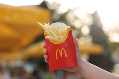 Photo of Lviv, Ukraine - September 26, 2023: Woman with McDonald's french fries outdoors, closeup