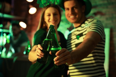 Couple with beer celebrating St Patrick's day in pub, focus on hands