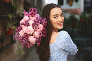 Photo of Beautiful woman with bouquet of spring flowers outdoors