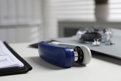 Photo of Stapler on white table indoors, closeup view