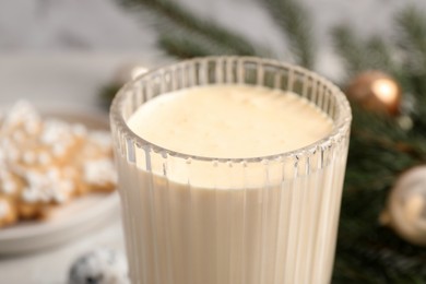 Photo of Glass of delicious eggnog on table, closeup