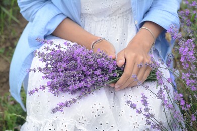 Photo of Woman with bouquet of beautiful lavender flowers outdoors, closeup