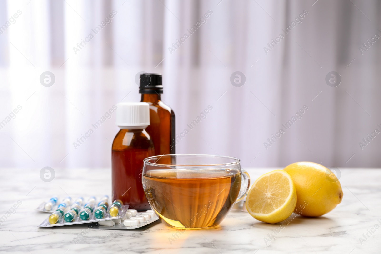 Photo of Cup of hot tea and different cough remedies on table