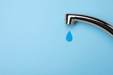 Photo of Paper water drop and modern tap on light blue background, flat lay. Space for text