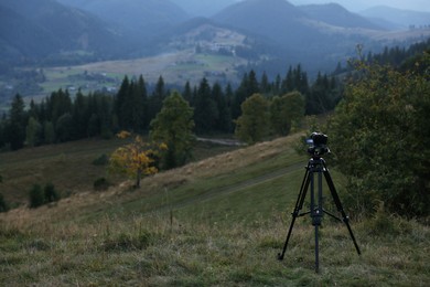 Taking photo of beautiful mountain landscape with camera mounted on tripod outdoors, space for text