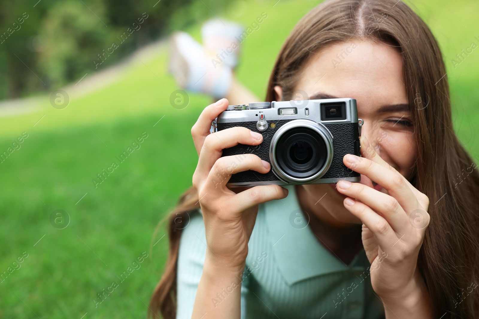 Photo of Young woman with camera taking photo outdoors, space for text. Interesting hobby