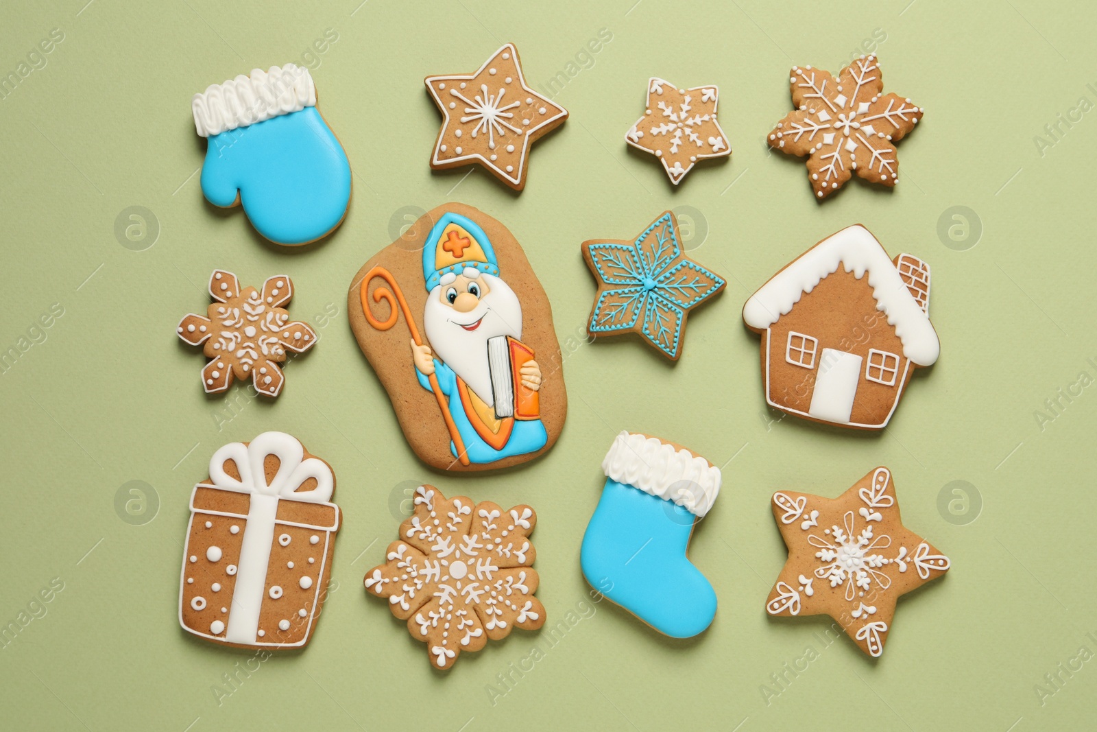 Photo of Tasty gingerbread cookies on light green background, flat lay. St. Nicholas Day celebration