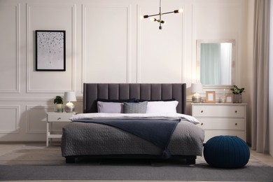 Photo of Stylish bedroom interior with large comfortable bed and chest of drawers