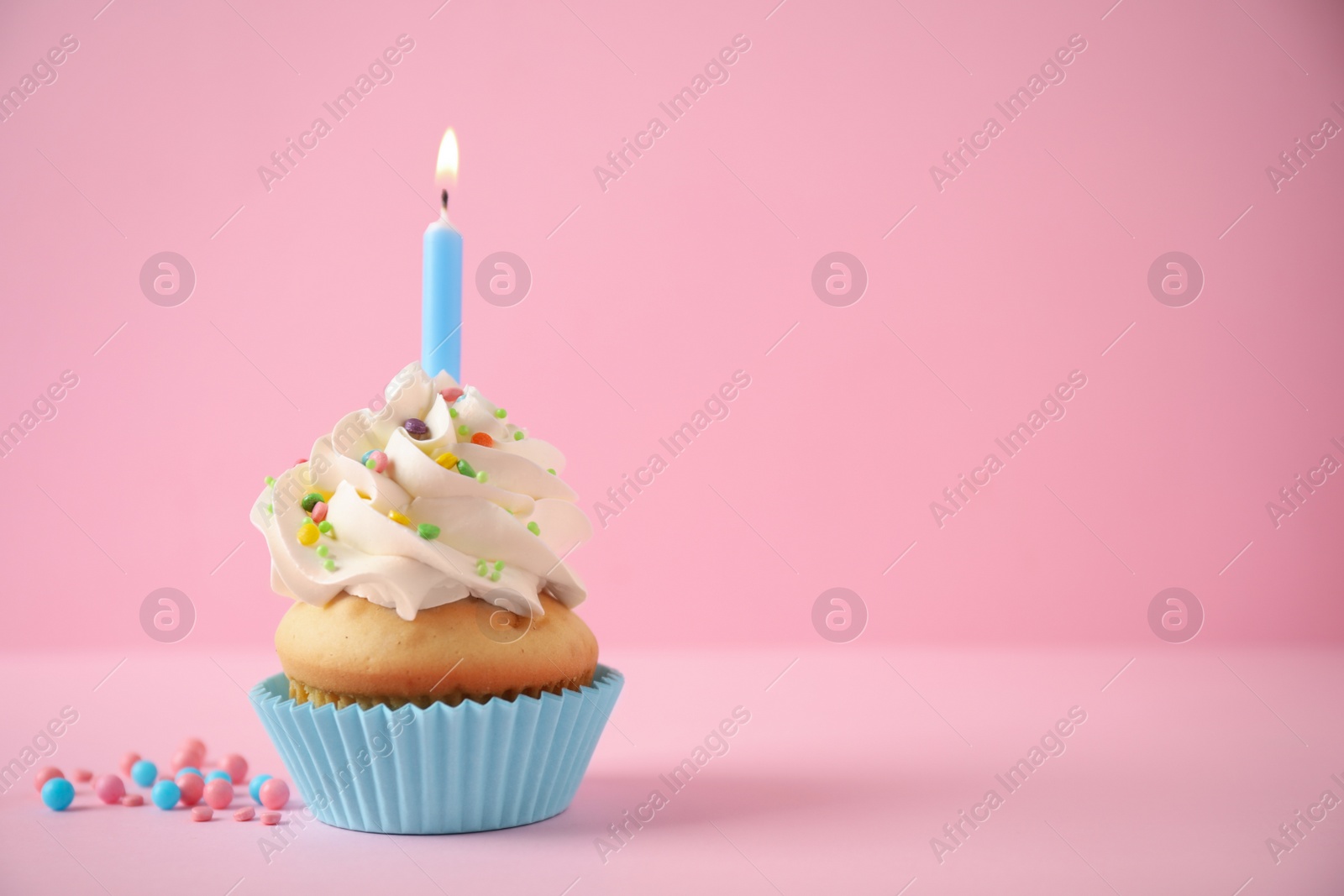 Photo of Delicious birthday cupcake with candle on pink background. Space for text