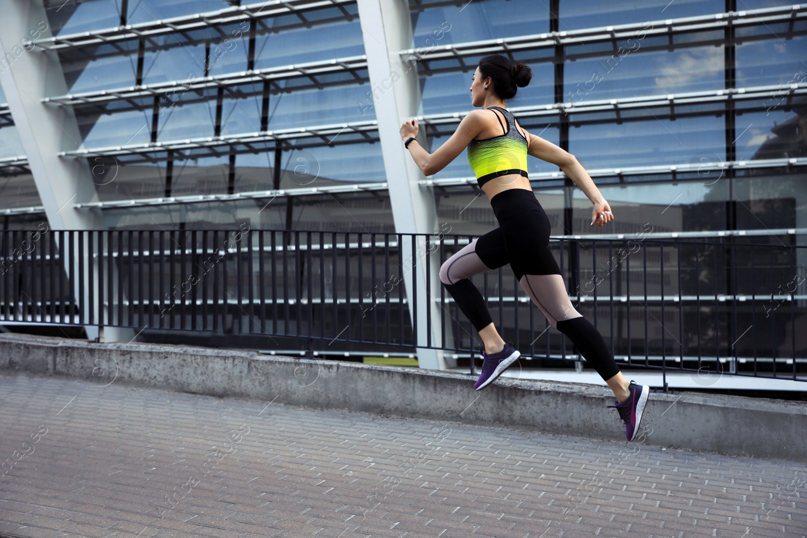 Photo of Beautiful sporty young woman running on street