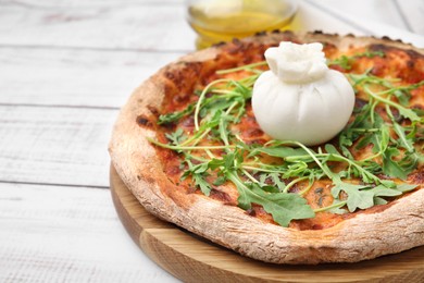 Delicious pizza with burrata cheese and arugula on white wooden table, closeup