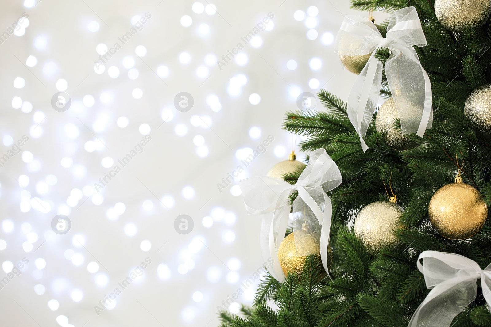 Photo of Beautiful decorated Christmas tree against blurred lights, closeup with space for text. Bokeh effect