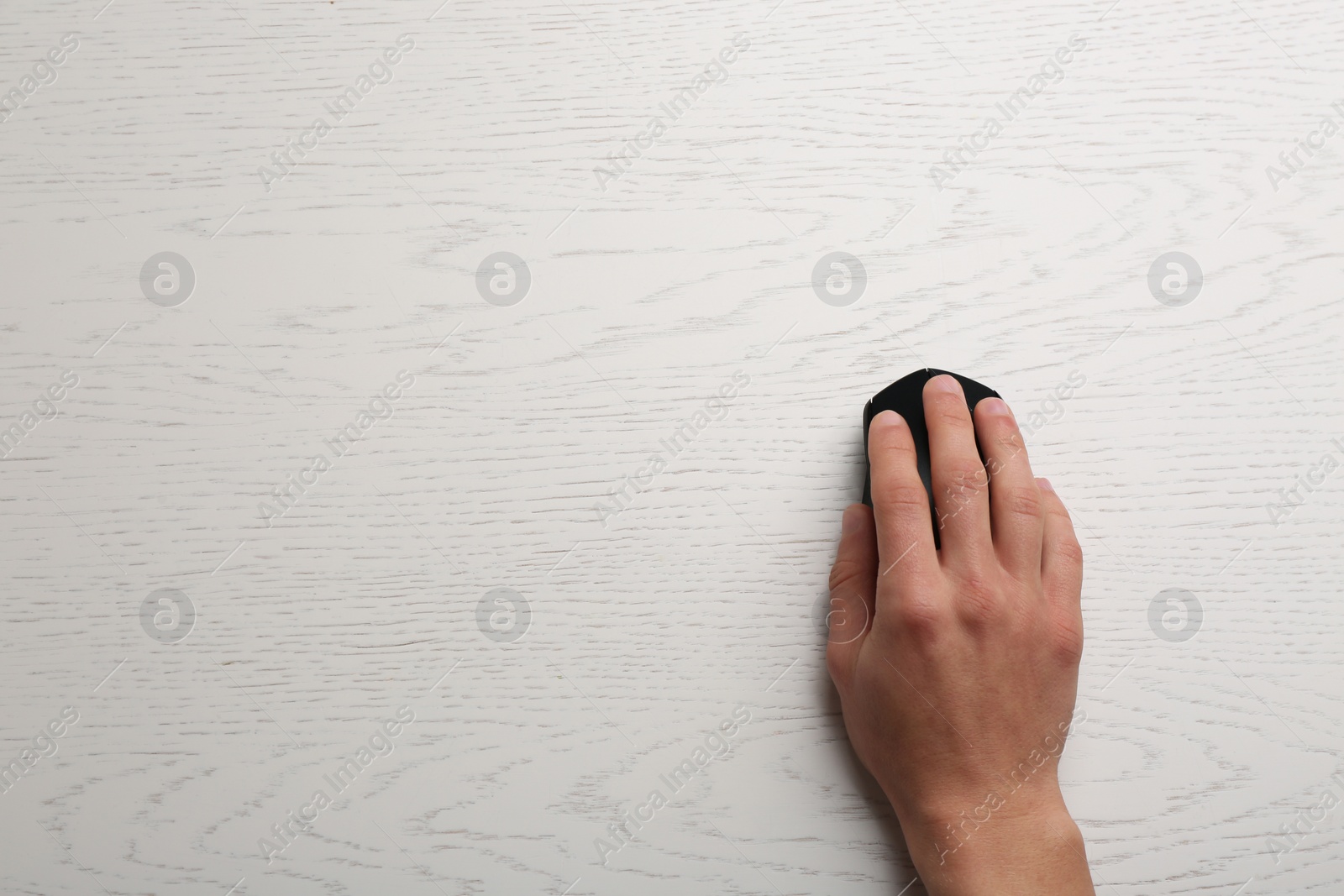 Photo of Man using computer mouse on wooden table, top view. Space for text