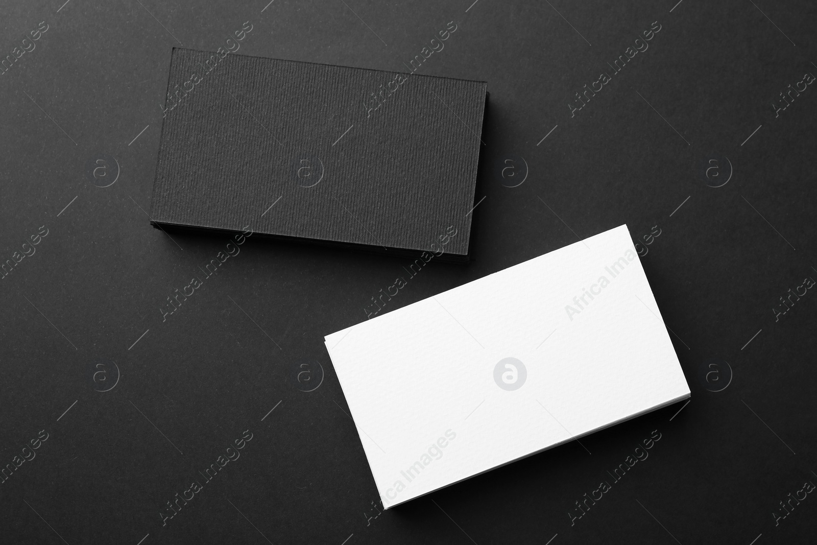 Photo of Blank business cards on black background, flat lay. Mockup for design