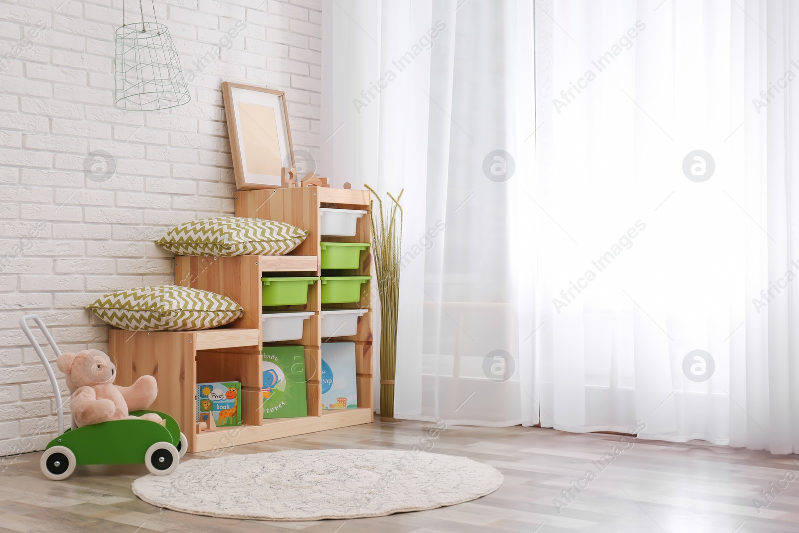 Photo of Modern eco style interior of child room with wooden crates near brick wall. Space for text